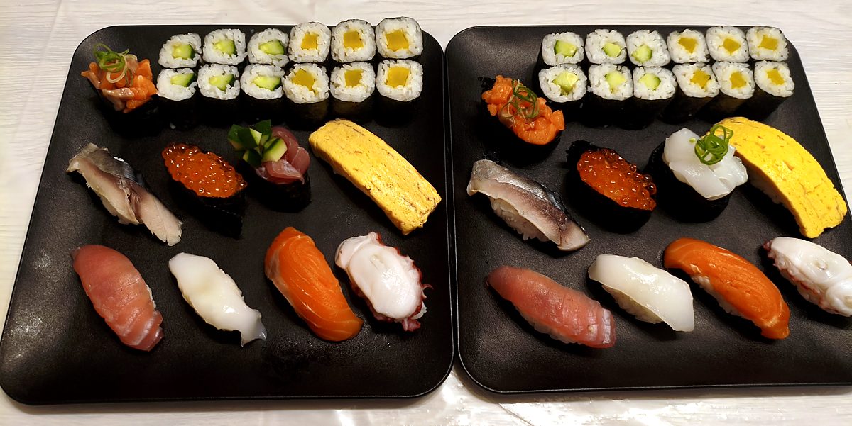 Two platters of nigiri, gunkan and maki rolls made by students