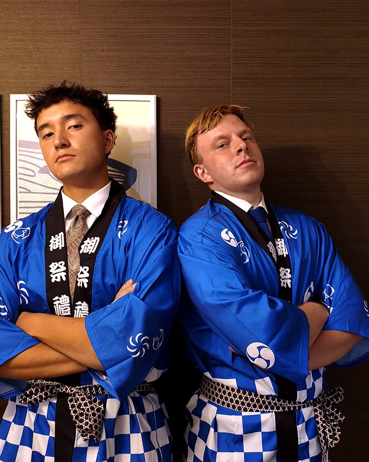 Two guests posing with arms crossed in happi coats